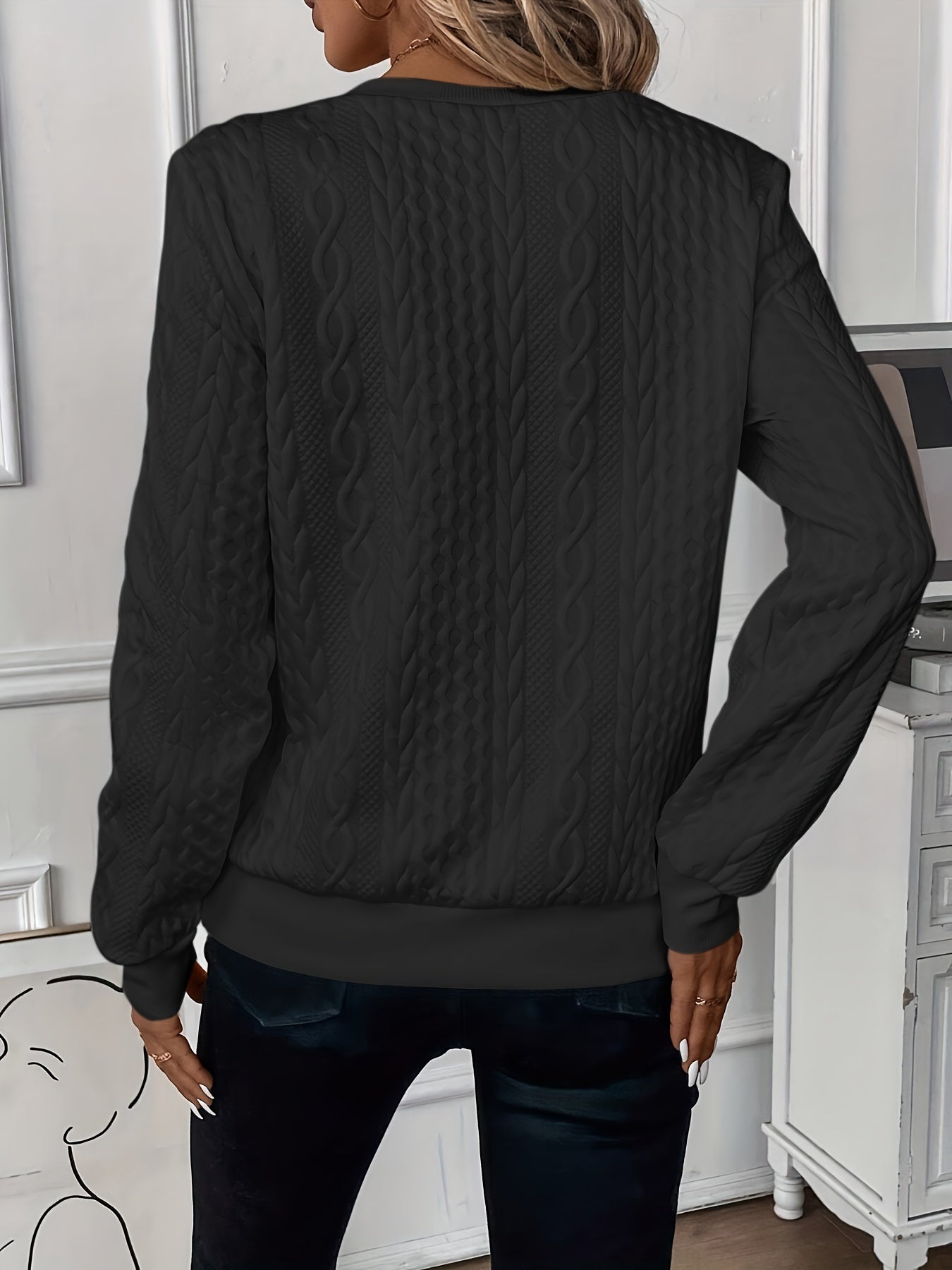 Cable-knit sweater seen at full length