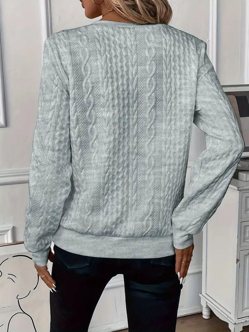 Cable sweater photographed at an angle