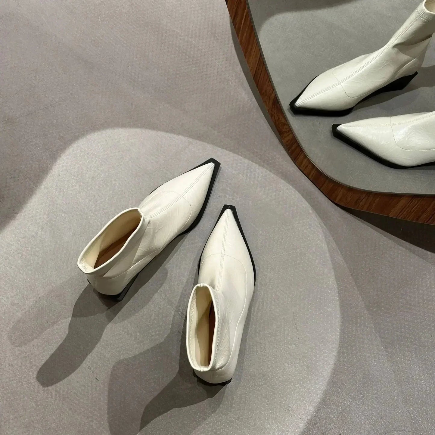 Pointed ankle boots shown in cream