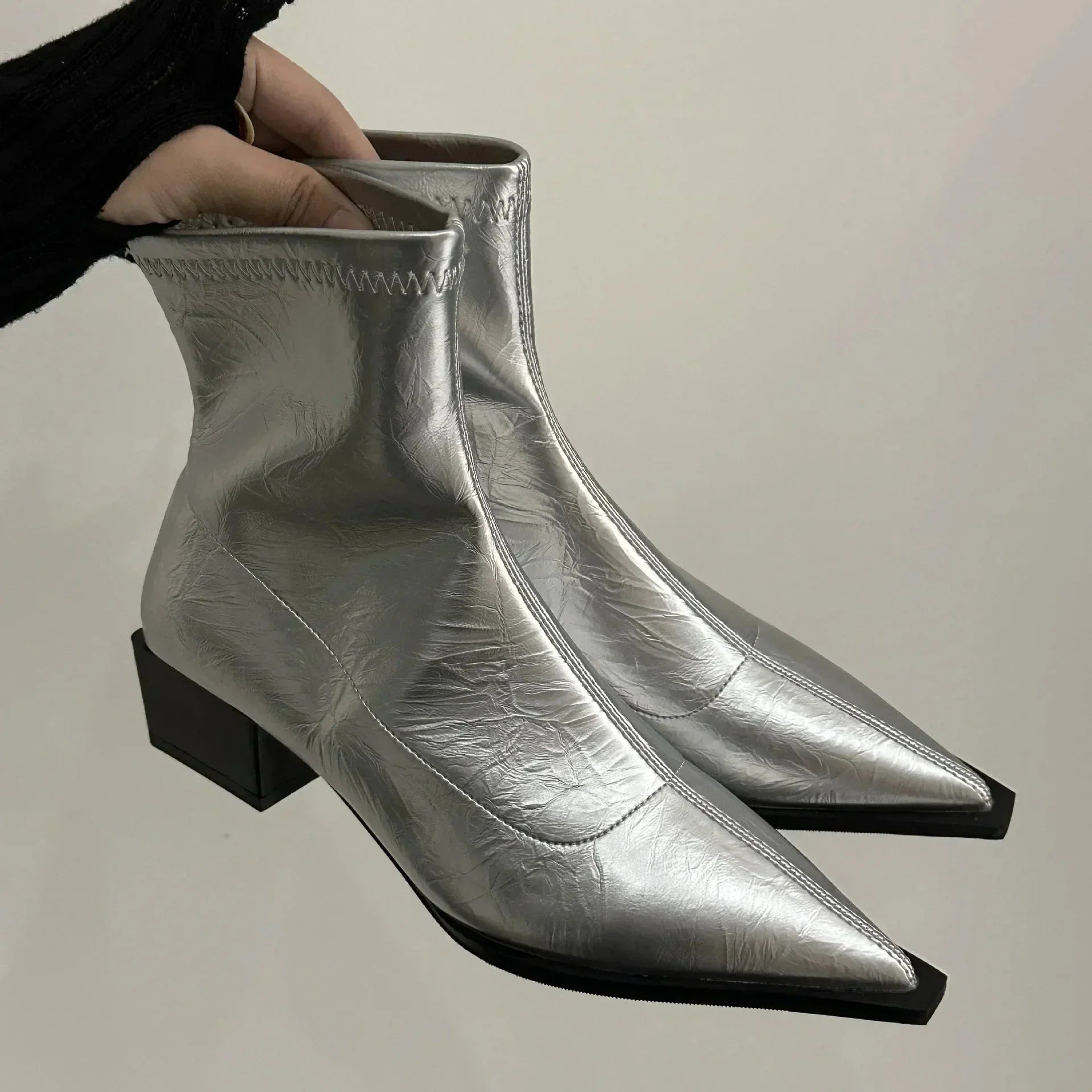 Pointed-toe ankle boots in silver, side view